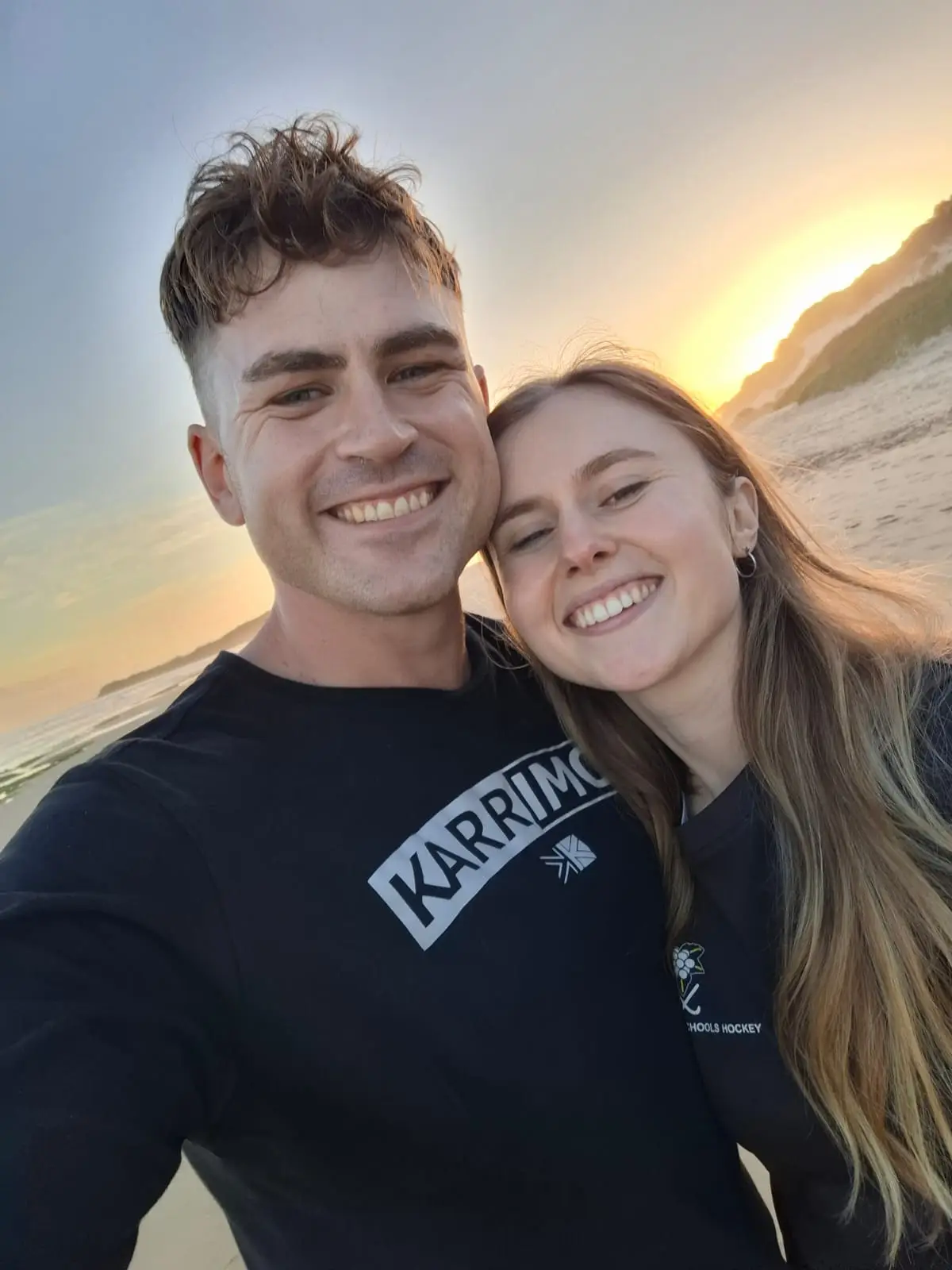 Ockert en Emja op die strand terwyl die son sak.